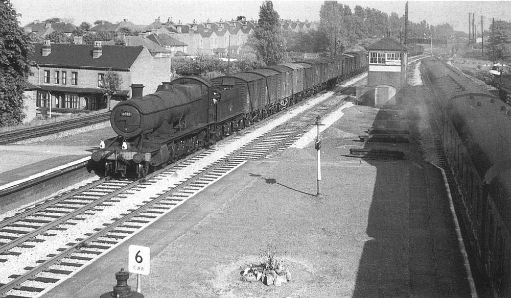 Ex-GWR 2-8-0 28xx Class No 2818 is seen with a fitted freight passing through the station's down main line on 4th June 1958