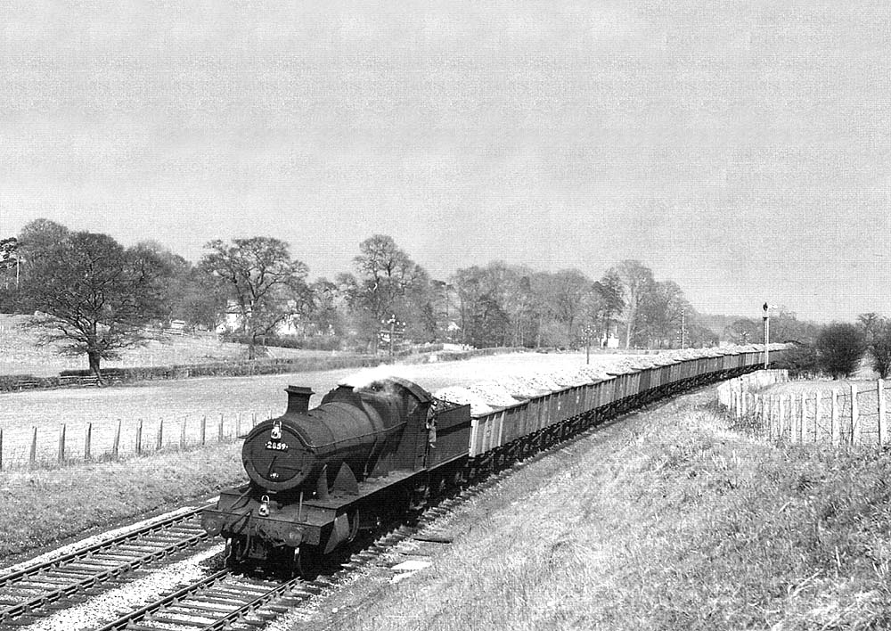 Ex-GWR 2-8-0 28xx Class No 2859 passes Bearley distant signal with an iron ore train for South Wales in 1956