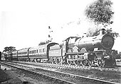 An unidentified GWR 4-6-0 Star class at the head of a London bound express with coaching stock carrying crimson lake livery
