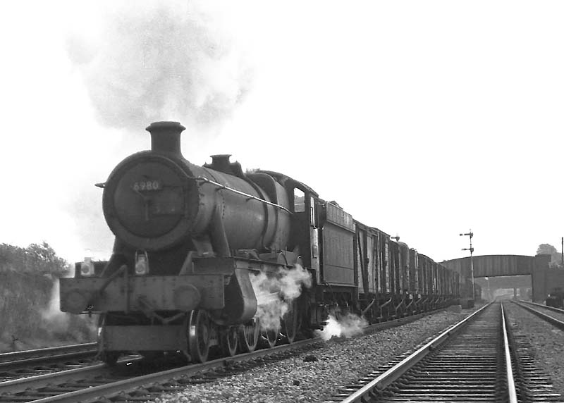 Ex-GWR 6959 Class 4-6-0 No 6980 'Llanrumney Hall' approaches Queens Head sidings with a down goods train on 26th September 1964