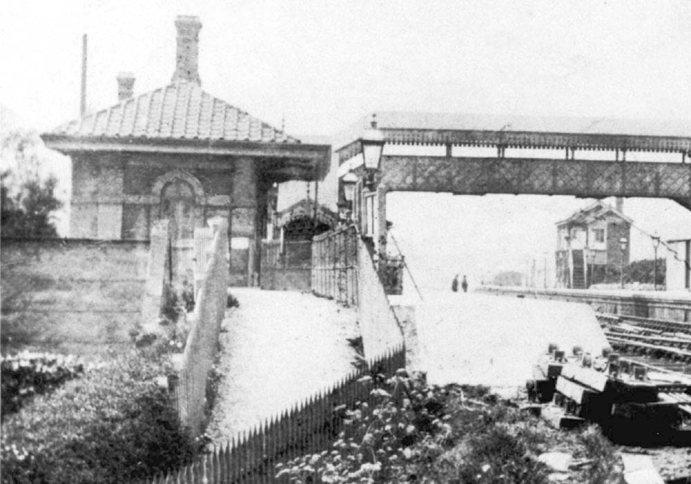 Close up showing the original down platform building and the passengers footbridge with the original signal box in the background
