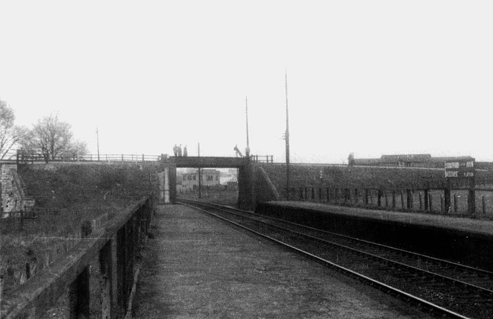 Looking North along 'Racecourse's up platform and through the former SMJ railway bridge towards Stratford on Avon station circa 1956