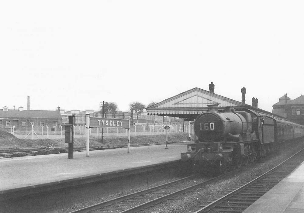 An unidentified ex-GWR 4-6-0 Castle Class class locomotive passes through the station on the down main line circa 1955