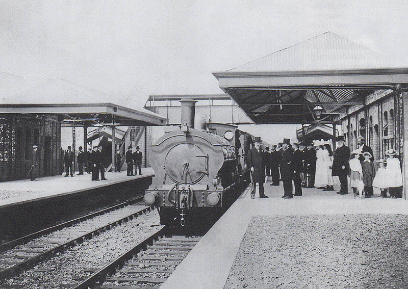 An unidentified GWR 0-6-0PT locomotive stands at the up platform during celebrations marking the opening of the station on 1st July 1899