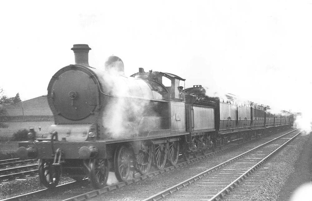 LNWR 4-6-0 2P Experiment class No 496 'Harlequin' is seen at the head of an up Stafford to Rugby local passenger train near Atherstone
