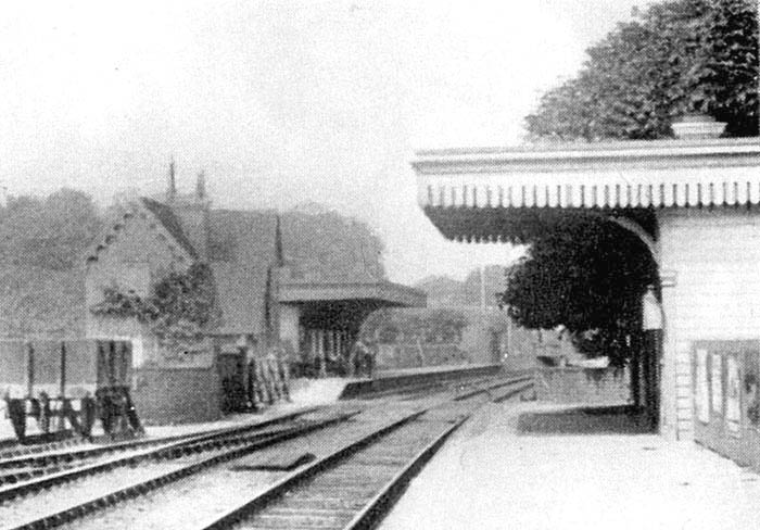 Close up showing the two platforms staggered either side of the level crossing and the under-bridge with the station master's house on the left