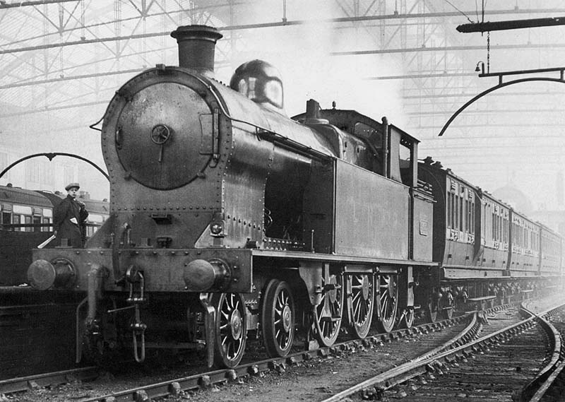 Ex-LNWR 4-6-2T No 962 is seen still in its LNWR livery standing at the West end of Platform One with coaches forming a Coventry to Birmingham local service