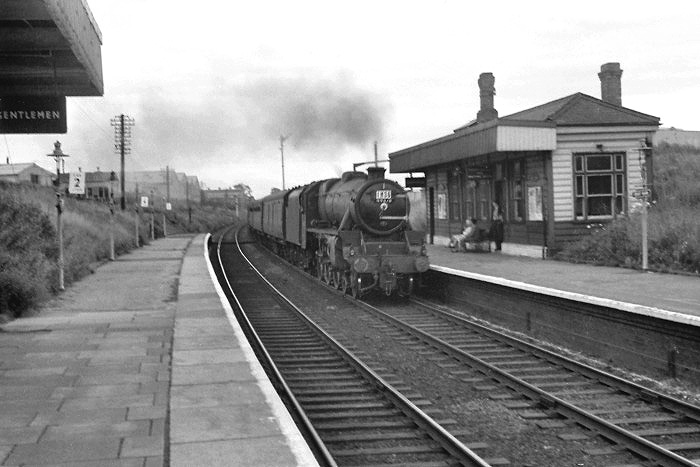 An unidentified ex-LMS 4-6-0 'Black Five' locomotive is seen passing through the station on a down service to Stafford in the early 1960s