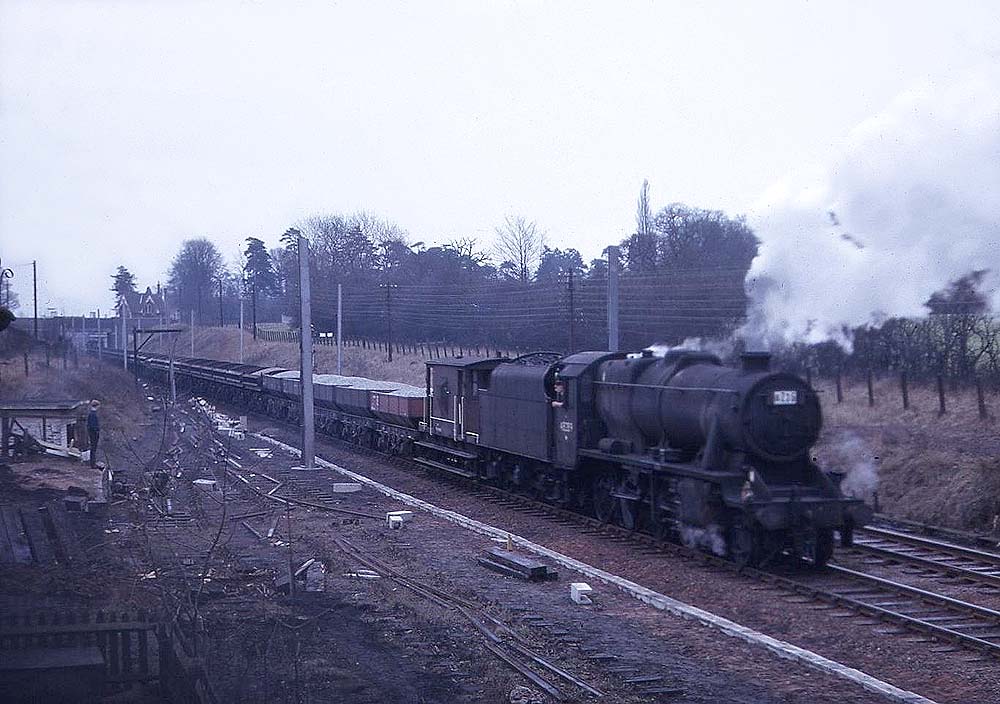 An unidentified ex-LMS 2-8-0 8F locomotive is seen working wrong line on a ballast train on 1st February 1965