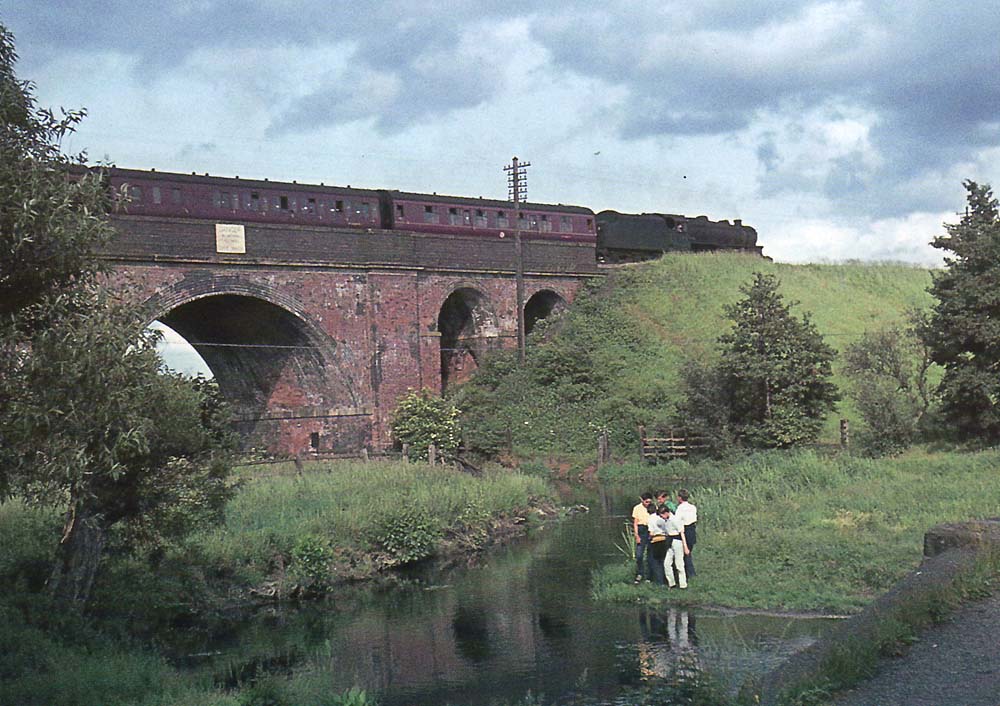 British Railways built 4-6-0 5MT No 44715 passes over the River Blythe on what is thought to be the 5:48pm New Street to Rugby service on 27th June 1963