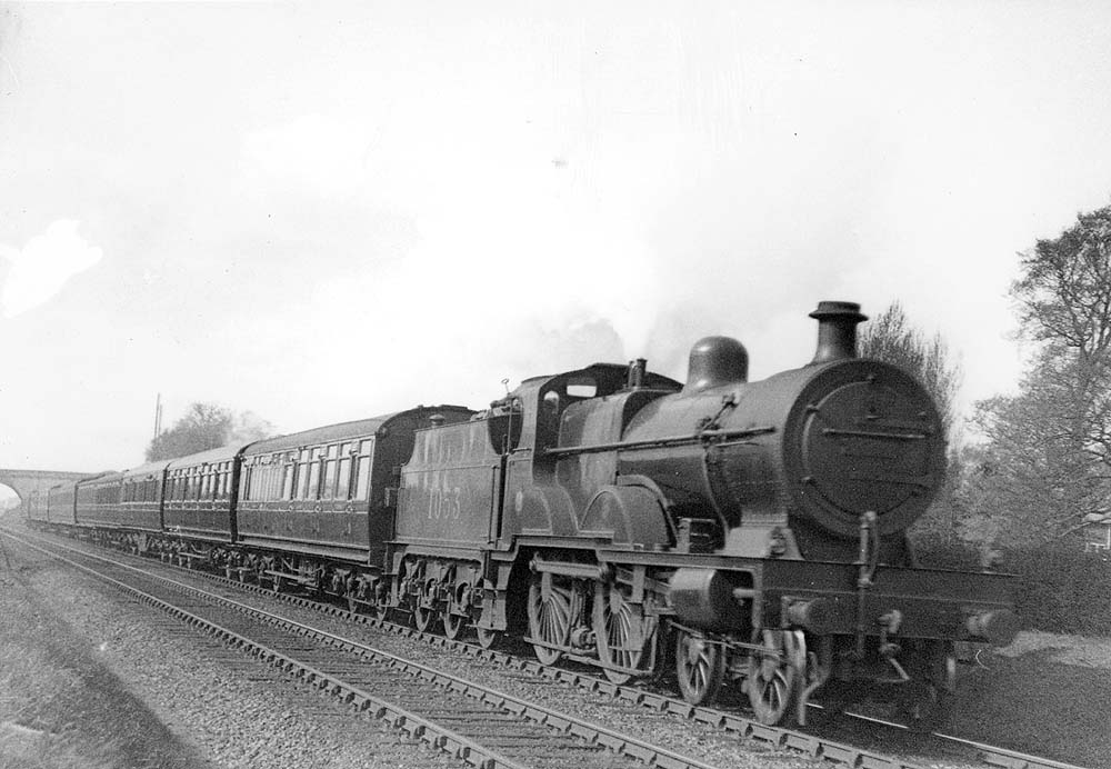 LMS 4P Compound 4-4-0 No 1053 is seen with steam blowing off from its safety valves whilst on an up two-hour express service near Hampton in Arden