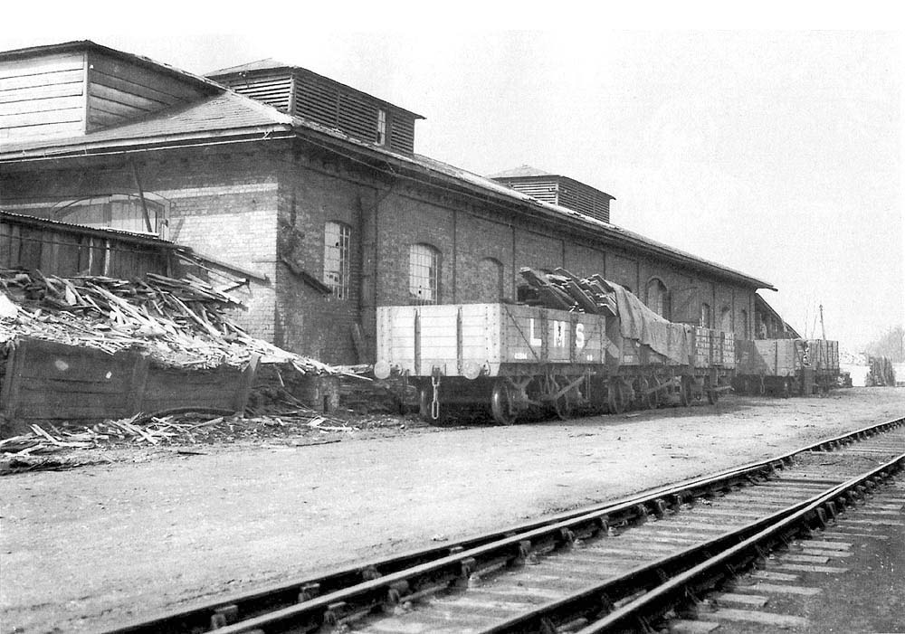 A 1931 view of the former engine shed with a number of open five plank wagons being loaded for transhipping to markets elsewhere