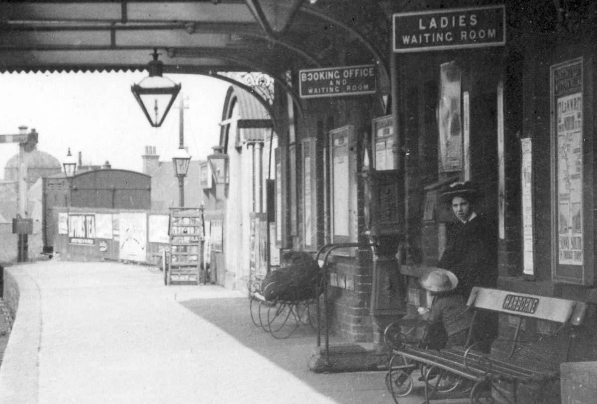 Close up showing the station building and at the end of the platform a horsebox stabled at the horse carriage landing