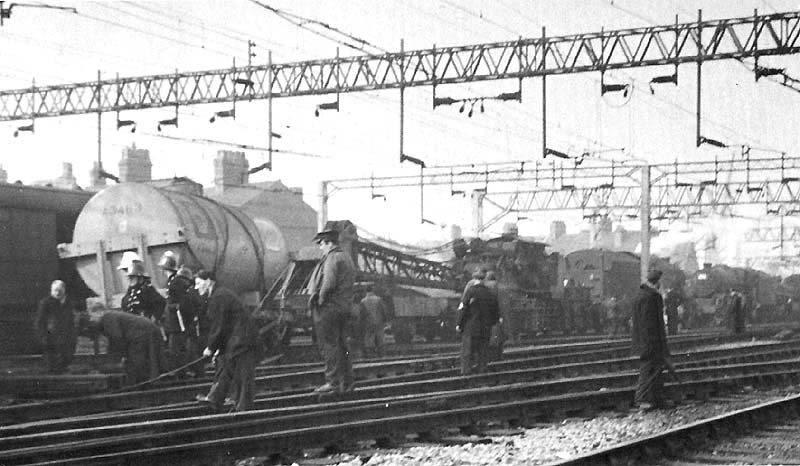 Railway workers and firemen deal with the aftermath of a derailment of petrol tank wagon south of Nuneaton station on 13th October 1964