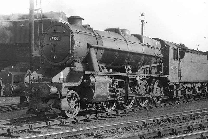Ex-LMS 2-8-0 8F No 48258 is seen coupled to a Fowler 3500 gallon tender having just been coaled and watered and stands alongside the shed