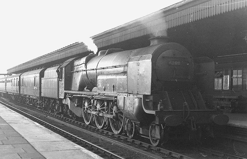 LMS 4-6-2 'Turbomotive' No 6202 is seen passing through Nuneaton station's platform three on a down express service