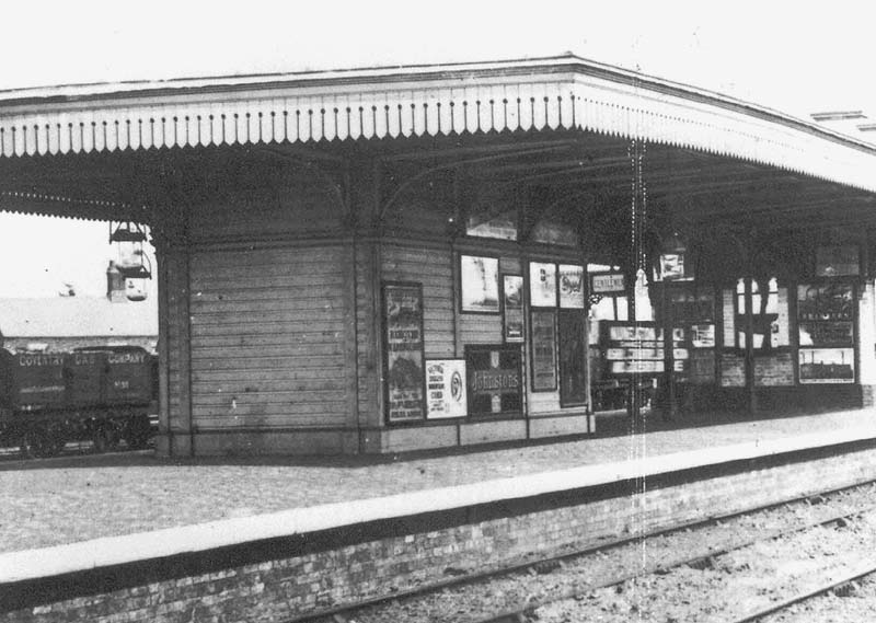 Close up of the island platform showing on the left the Gentlemen's toilet block with Nuneaton's station sign on the right