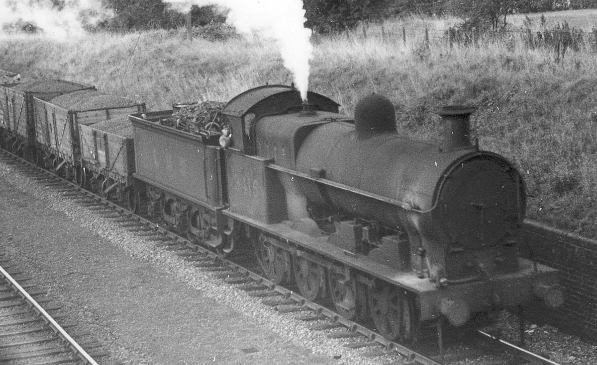 Close up showing ex-LNWR 7F 0-8-0 'G2' No 9415 in a very grimy and dirty condition with two types of coal in the wagons behind the tender