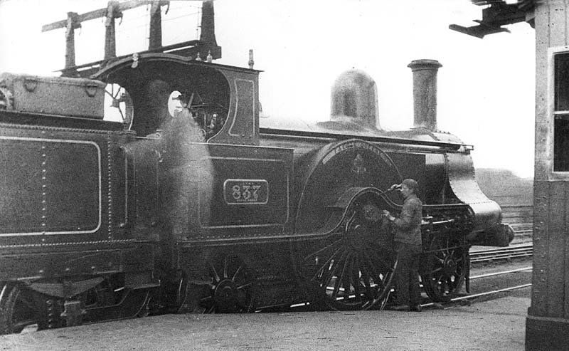 LNWR 2-2-2 Problem class No 837 'Faerie Queen' stands at the head of an up train whilst the driver oils the bearings