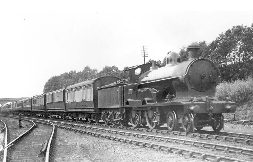 An unidentified LNWR 4-4-0 4P George Fifth class locomotive is seen a down express near Shilton station