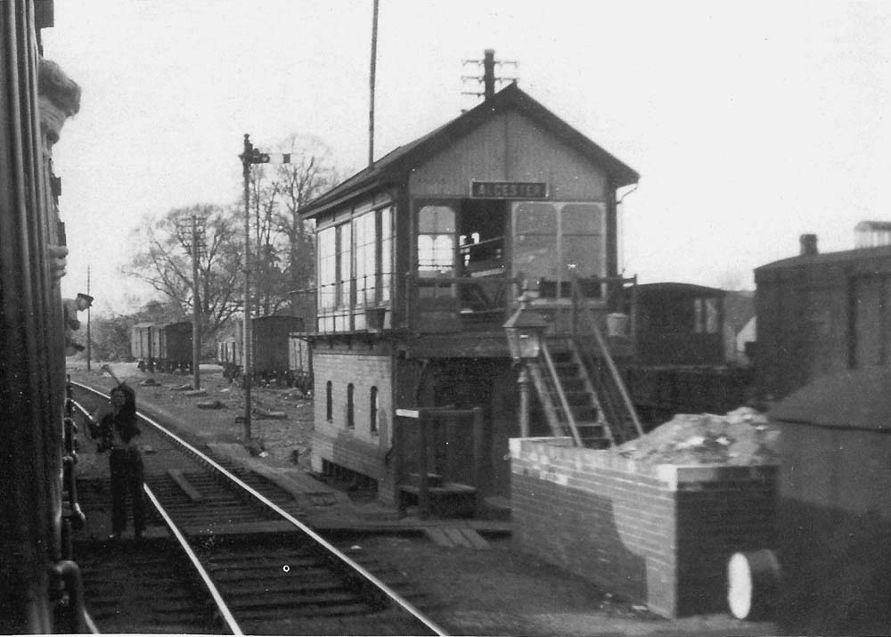 The signalman stretches up to the fireman as they exchange the single line staff in this view taken from a Birmingham bound train