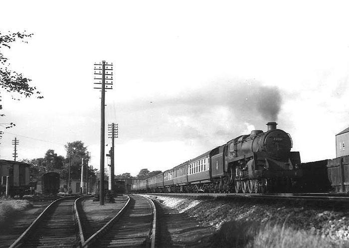 British Railways 5MT 4-6-0 No 73001 heads a southbound express past Cadbury's sidings on Sunday 12th September 1954