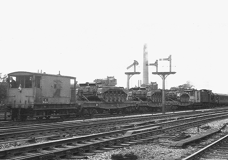 View of a goods train carrying three army tanks on a special train hauled by ex-LMS 0-6-0 4F No 44171