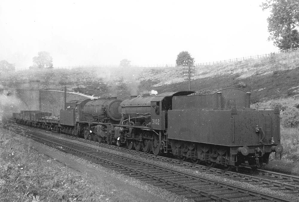 A pair of ex-WD 2-8-0 LNER Class O7s, No 3102 and No 3084, are seen leaving Catesby Tunnel on a down goods train on 30th August 1947