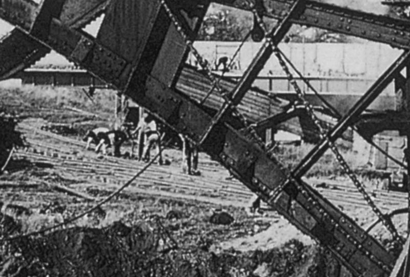 Close up showing the steel road bridge work and the work being undertaken behind the steam navvy