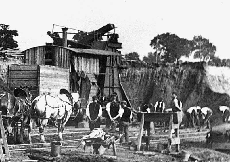 Close up showing the face of the cutting being excavated and the steam shovel which is fully enclosed