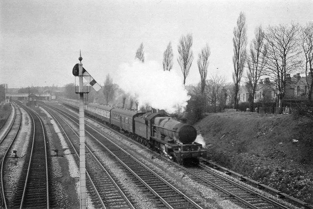 British Railways built 4-6-0 No 7008 'Swansea Castle' approaches Woodcock Lane bridge at the head of an up express