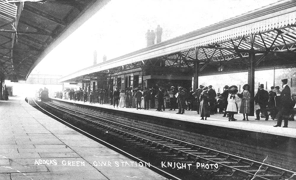 Looking towards Leamington as a local passenger train passes under the footbridge as it arrives at the down main platform