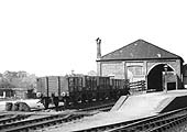 Close up showing the goods shed and a rake of five open mineral wagons standing in front of the cattle dock