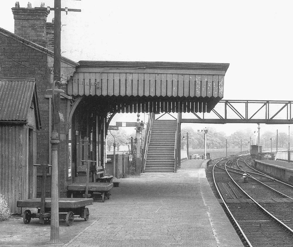 Close up showing the front elevation of the original 1876 main station building with porter's trollies on the platform