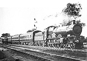 An unknown GWR 4-6-0 Star class locomotive is seen at the head of a rake of GWR brown lake liveried coaches