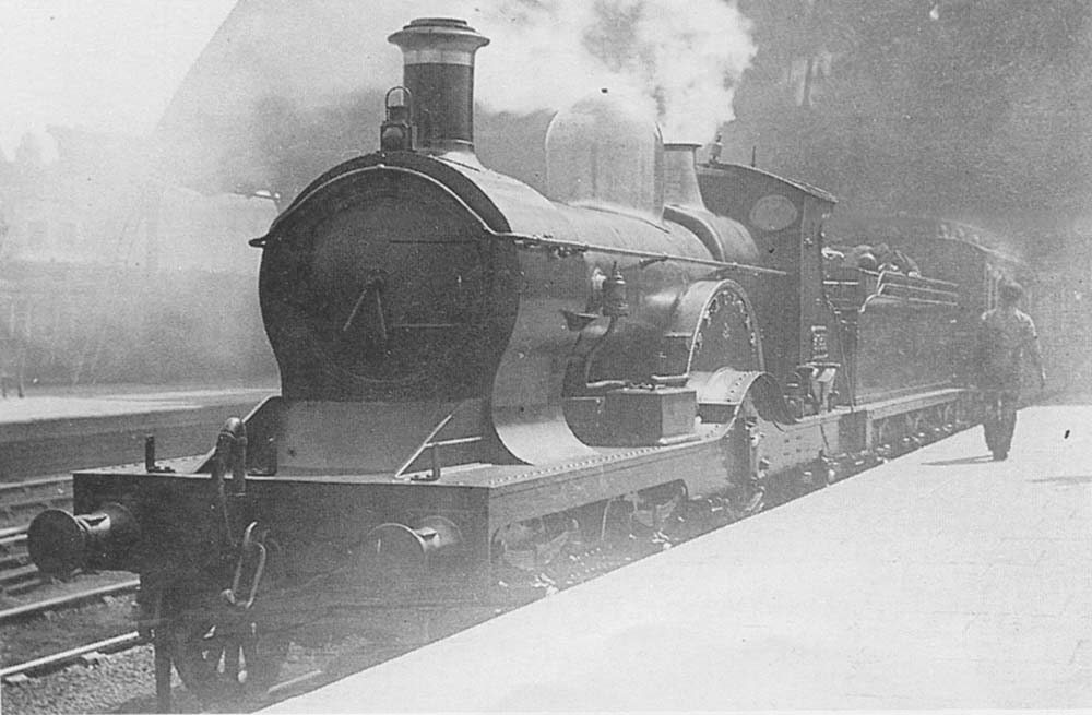 GWR 4-2-2 'Dean Single' No 3035 'Beaufort' is seen with steam escaping from is safety valves as it stands at the head of a down express to Wolverhampton