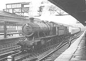 Ex-GWR 2-8-0 class 28xx No 2809 is seen passing through Snow Hill station's up through road whilst at the head of a train of underground rolling stock on 6th January 1958
