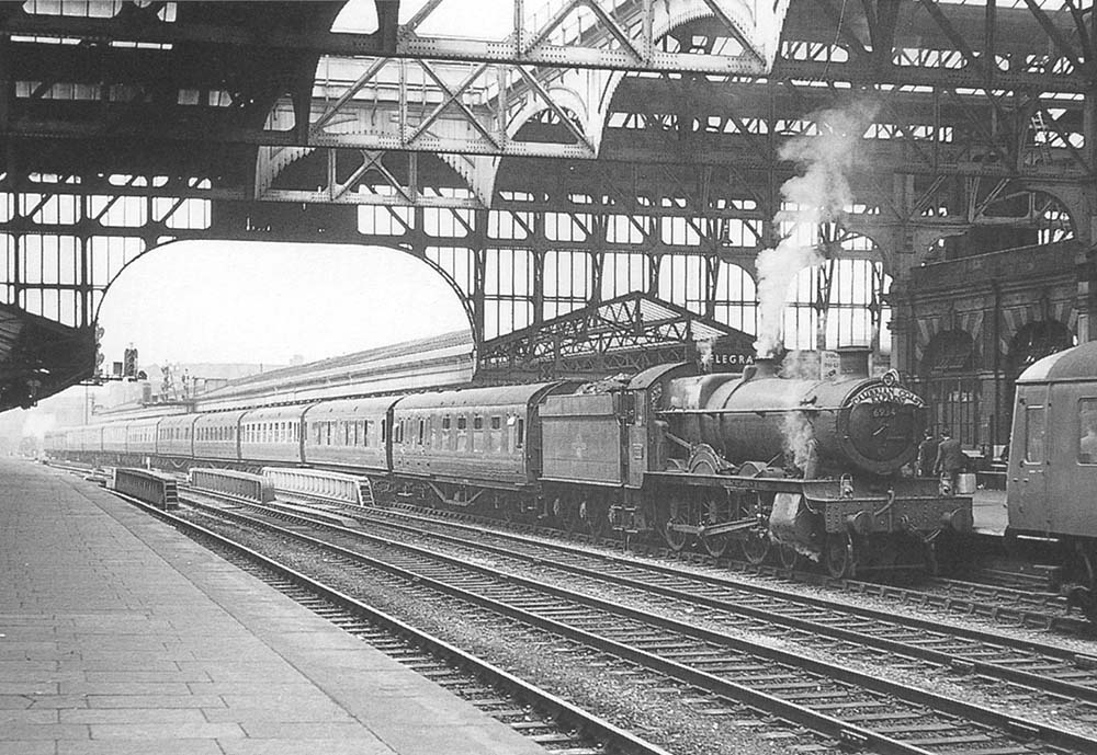 Ex-GWR 4-6-0 Hall class No 6934 'Beachamwell Hall' is seen with twelve coaches behind the tender whilst at the head of the up Cambrian Coast Express