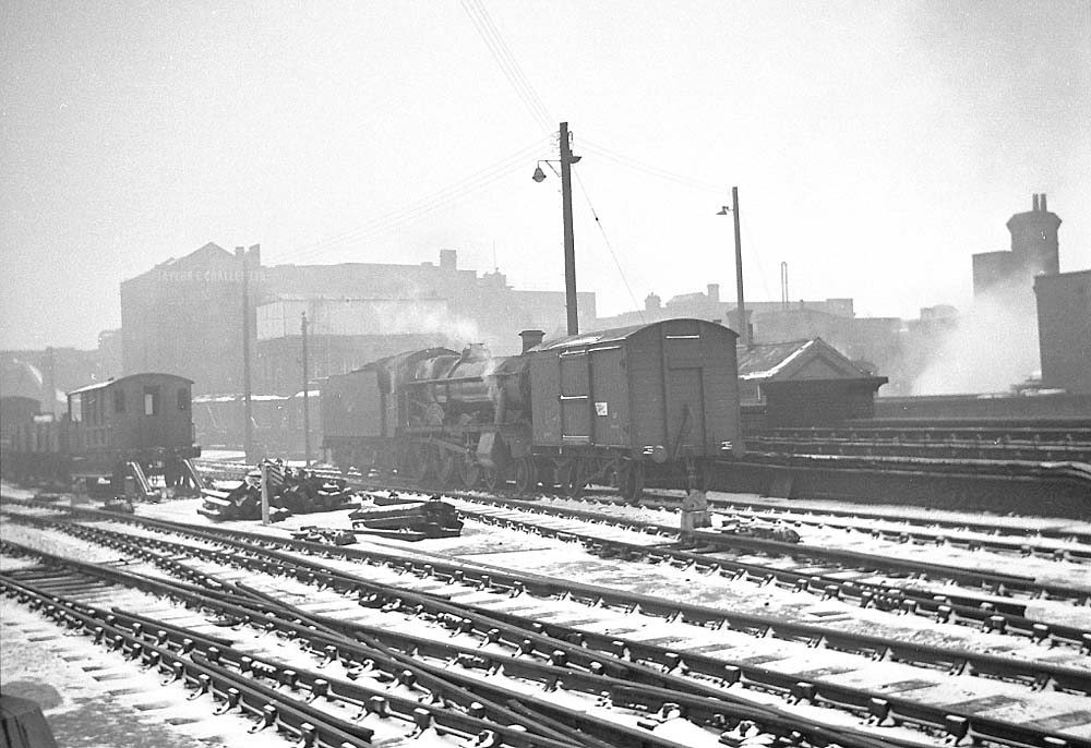 An unidentified ex-GWR 4-6-0 Modified Hall class locomotive is seen with snow on the ground shunting in the yard to the North of Snow Hill station