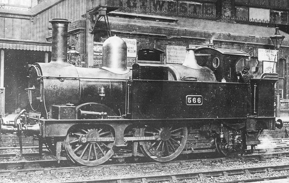 GWR 0-4-2T Class 517 No 566 is seen shunting stock on the up middle road in the shadow of the hotel at the South end of Snow Hill station