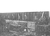 The first of the main girders being lowered on to their columns by the progressive removal of the sleepers