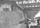 Porters continue sorting parcel traffic the heavily sand-bagged telegraph offices on Platform No 7 in 1940