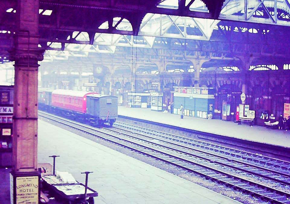 View from the steps descending to platform 5 showing a mixed rake of non-passenger vehicles on the through up line
