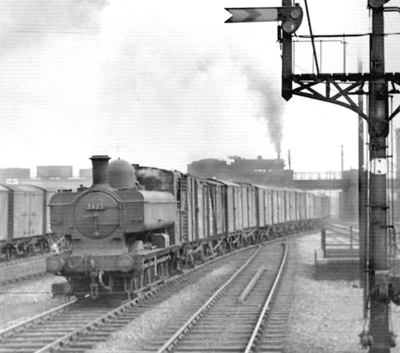 Ex-GWR 0-6-0PT No 3673, a class 51xx locomotive, is seen at the head of a freight passing under the former Midland line to Camp Hill