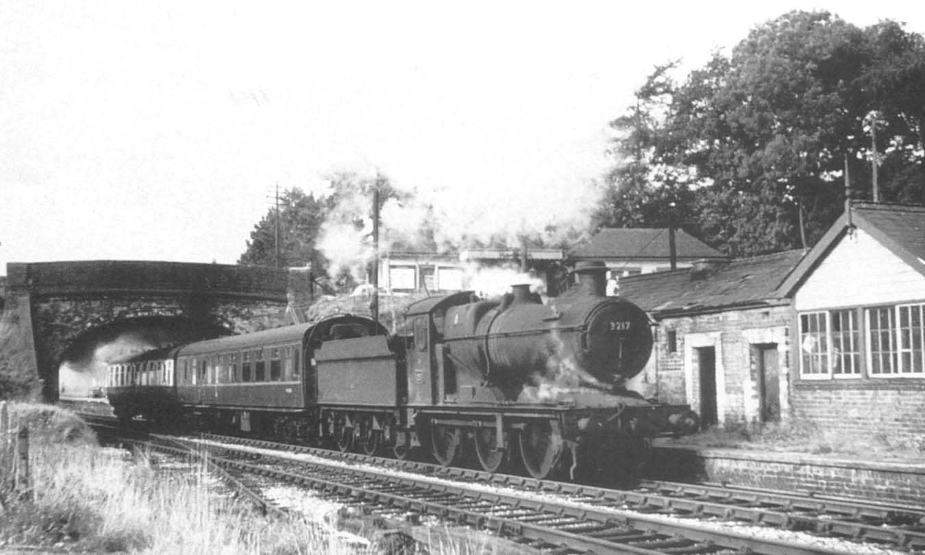 GWR Collett 0-6-0 2251 class No 3217 on a two coach train passes under the road bridge after leaving Claverdon station