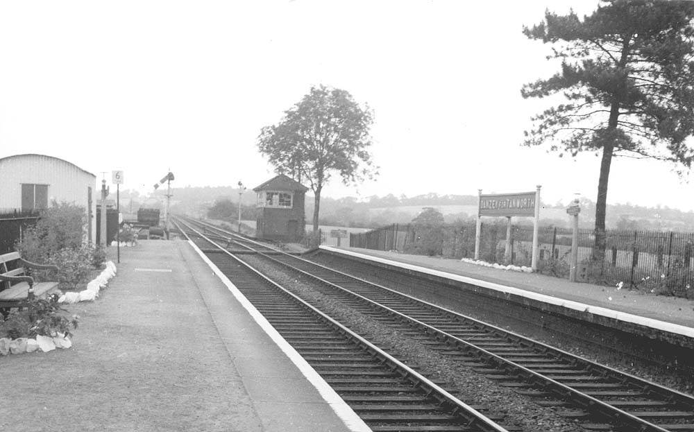 Looking towards Birmingham from beneath the passenger footbridge with a British Railways DMU stop sign seen adjacent to the platform lock up