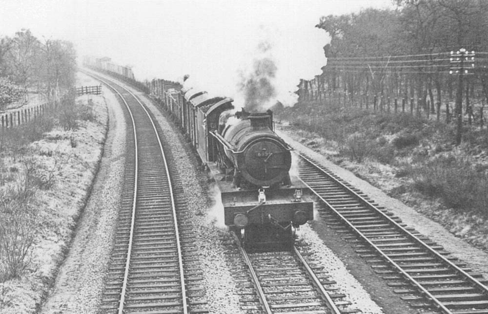 Ex-GWR 4-6-0 No 6956 'Mottram Hall' approaches Earlswood Lake station on an up Type 6 partially fitted freight
