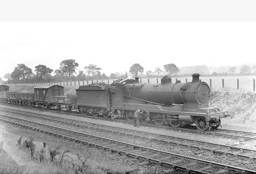 Ex-ROD 2-8-0 No 3014 is seen receiving attention whilst standing on the down refuge siding just beyond Rumbush Lane road bridge