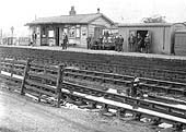 View of Fenny Compton station's up platform with ten non-uniformed railway workers posed for the camera