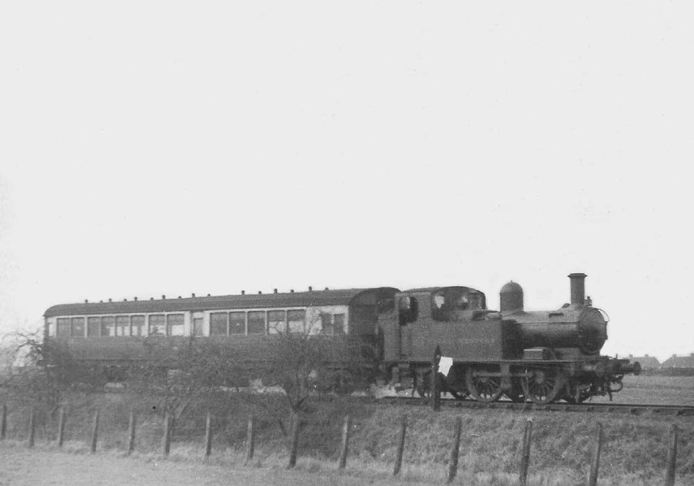 View of Auto trailer No 83 being hauled by an unidentified Collett 48xx class 0-4-2T locomotive